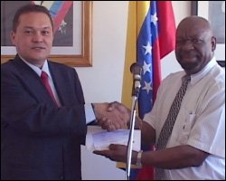 Cruz de Jesus Bello presents cheque to Gus Williams